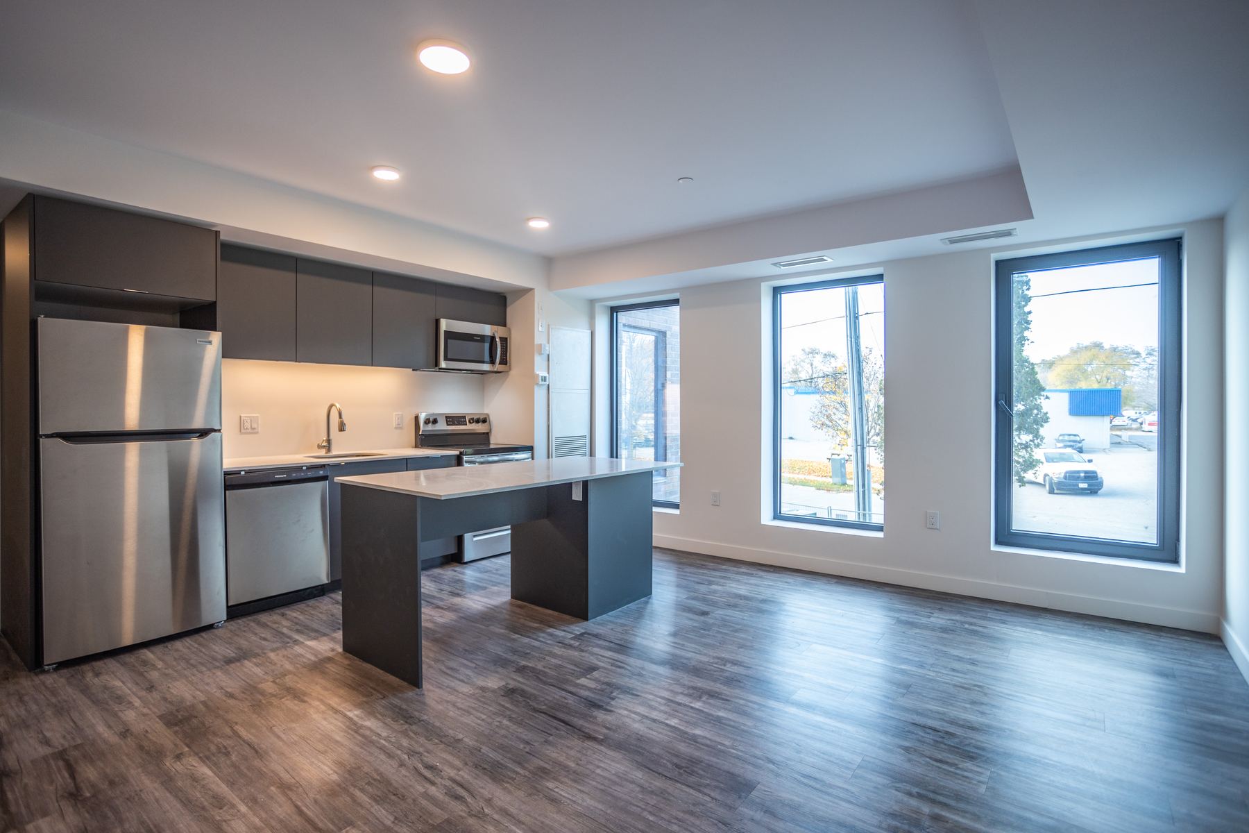 Open-plan living room and kitchen with island and large windows