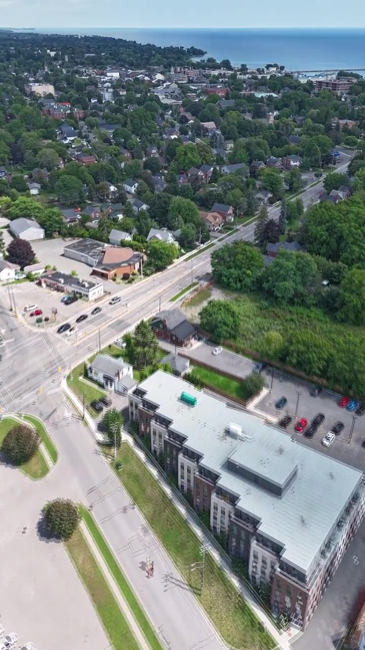 Aerial view over Cobourg rooftops and trees to Lake Ontario